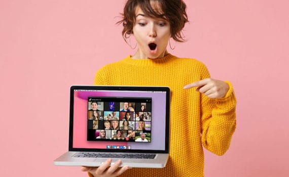 Woman pointing at the laptop screen where a Facebook Messenger Rooms call is ongoing