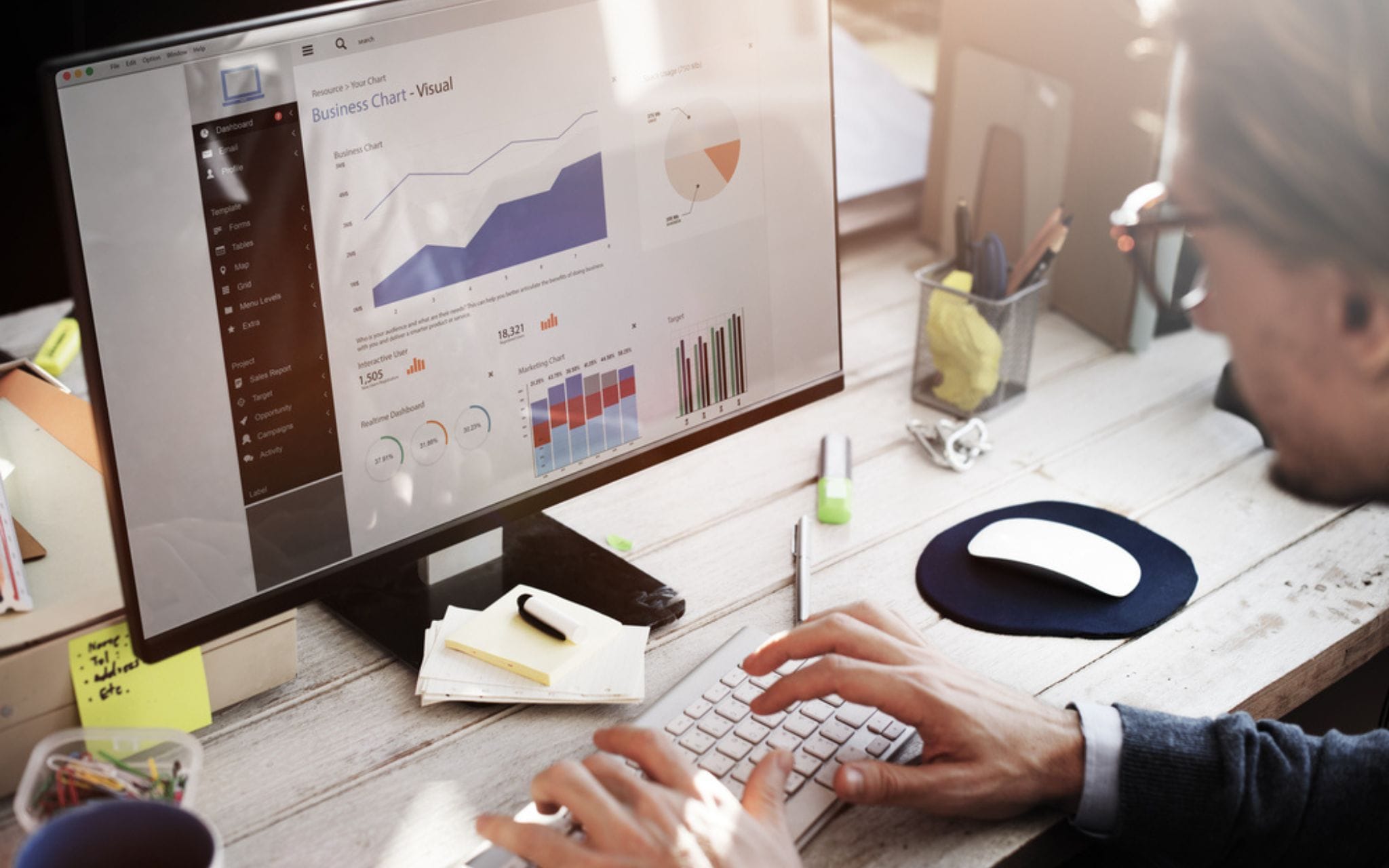 A man in glasses works on a computer
