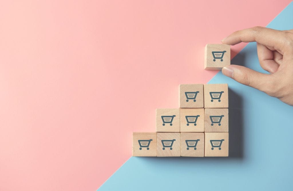 stylised picture of shopping trolley building blocks being used by a hand 