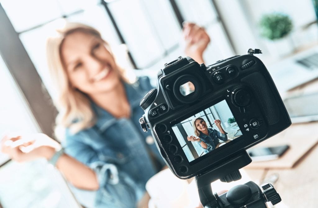 a woman creates video content using a camera