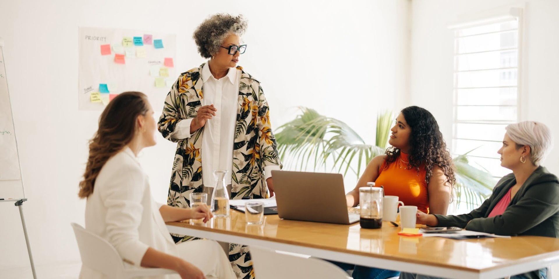 A female marketing manager, brightly dressed, leading a marketing meeting