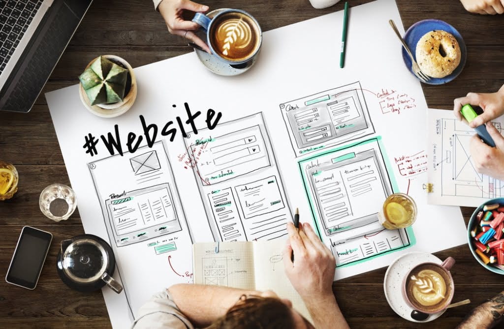 People sitting around a table designing image sizing for a website