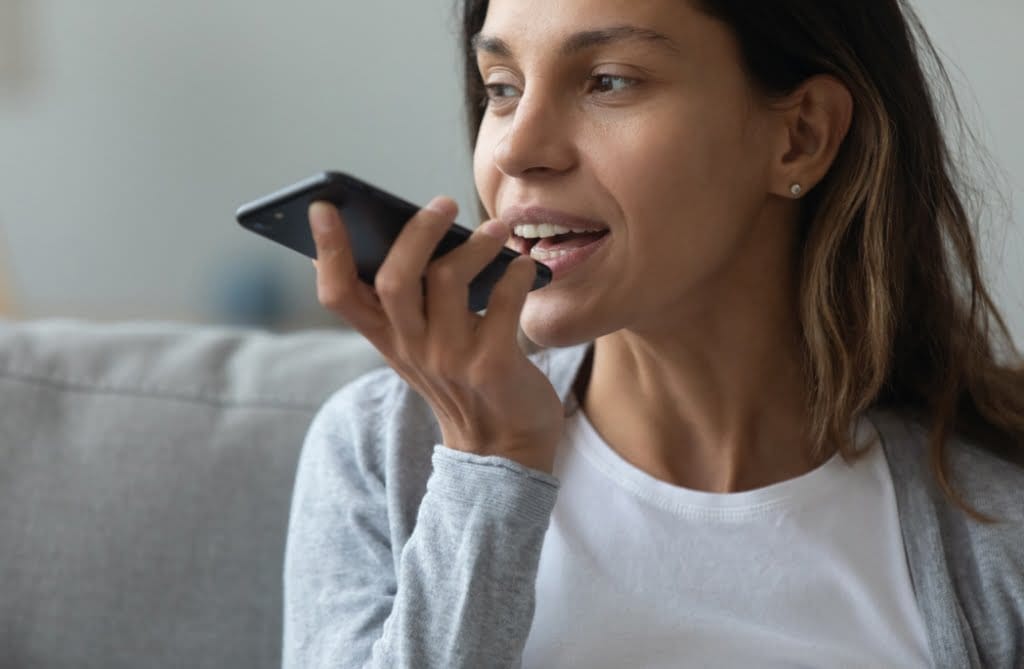 A woman uses voice activation on her phone's search engine