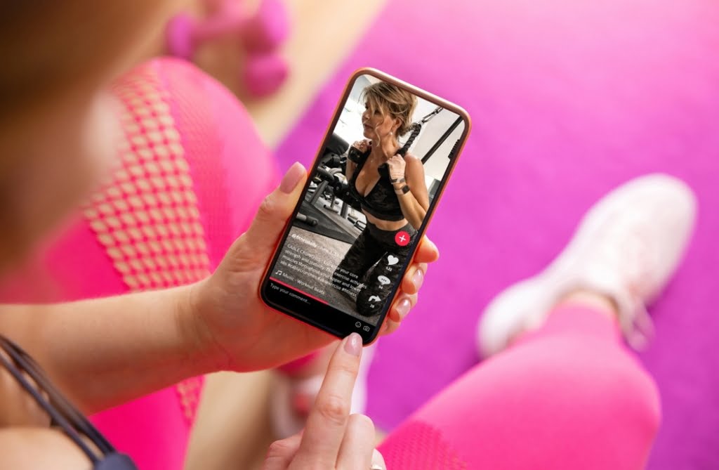 girl at the gym using tiktok on her phone