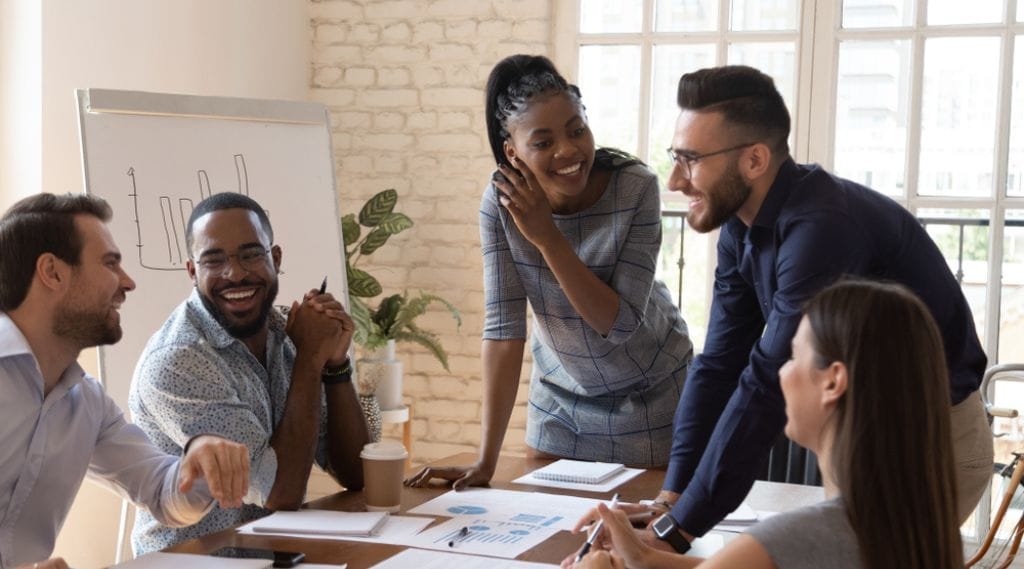A diverse team of marketers meet around a table