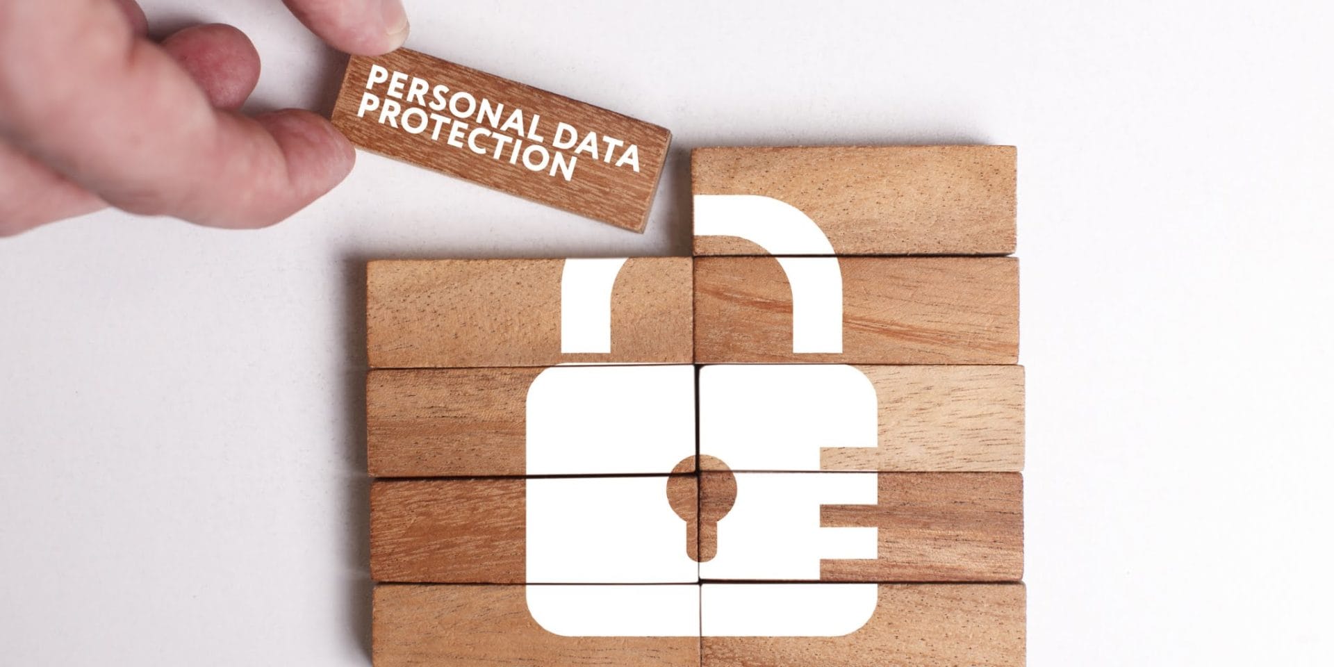 Header image depicting privacy in digital marketing. Wooden blocks making up a white padlock.