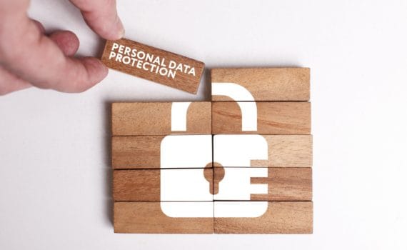 Header image depicting privacy in digital marketing. Wooden blocks making up a white padlock.