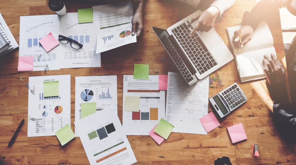 A team sits around a table coming up with a recession marketing plan