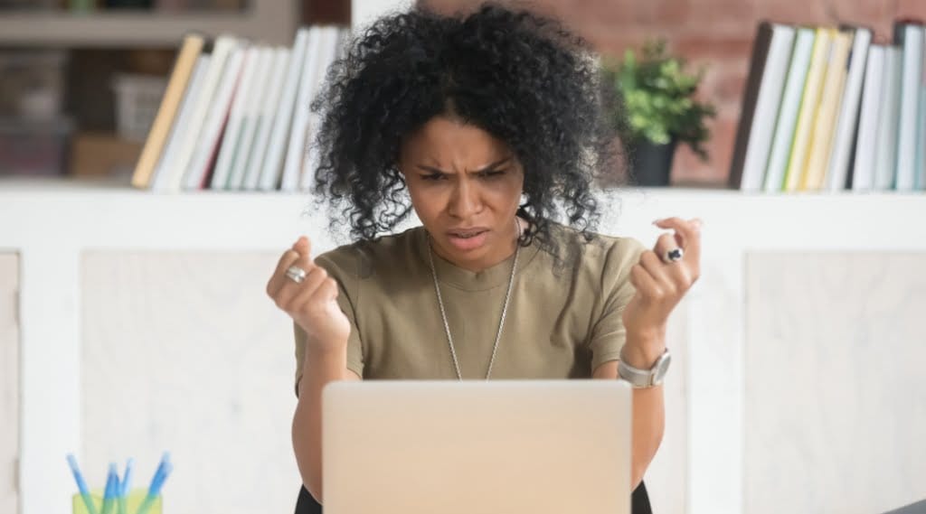A frustrated woman using an inaccessible website on a laptop