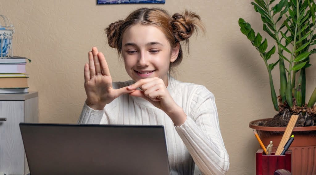 A young girl uses sign language while on an accessible website