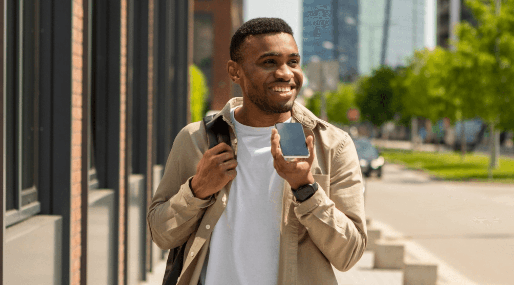 A man walking along using voice commands on his phone