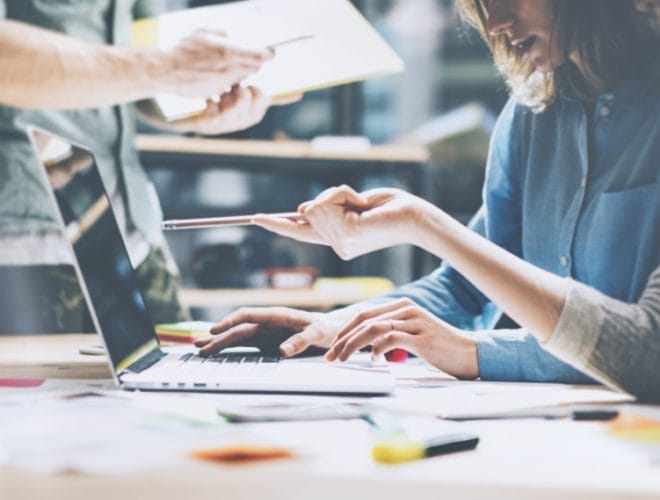 Marketing agency using a laptop to brainstorm