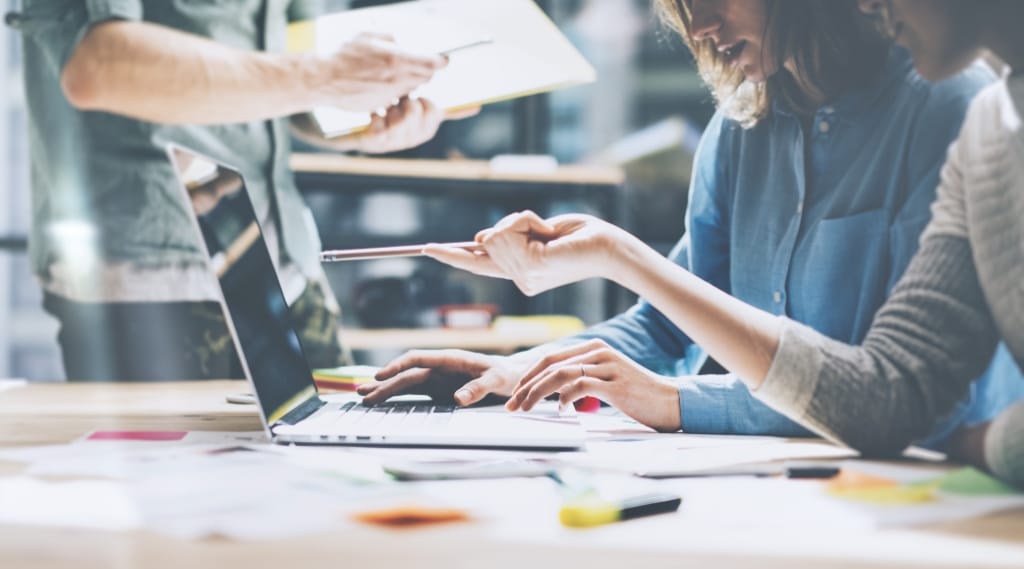 Marketing agency using a laptop to brainstorm