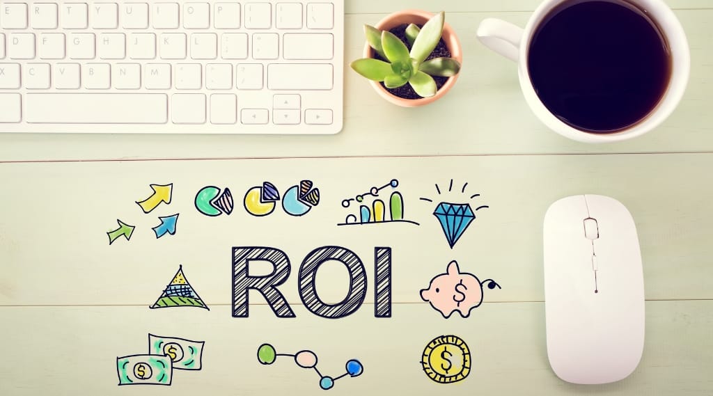 a stylised image of ROI - a mouse, coffee, and keyboard with 'ROI' written on a table with some cartoons