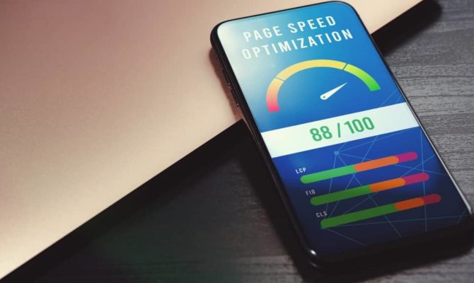 Smartphone showing 88/100 score for 7-second site speed test optimisation on a desk beside a laptop.