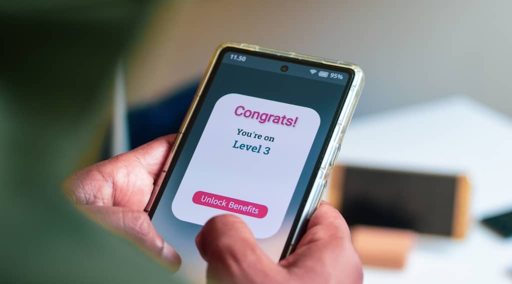 Smartphone screen showing “Congrats” message for reaching Level 3, symbolising customer loyalty rewards.