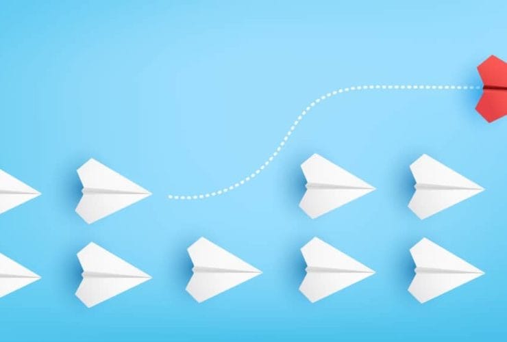 Illustration of red paper plane changing direction from white paper planes