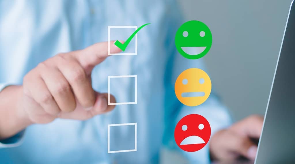 Person selecting a happy face icon in an online feedback survey