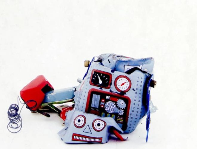 Broken toy robot on a white background, symbolising the risks of AI web design without a marketing agency or proper web development expertise.
