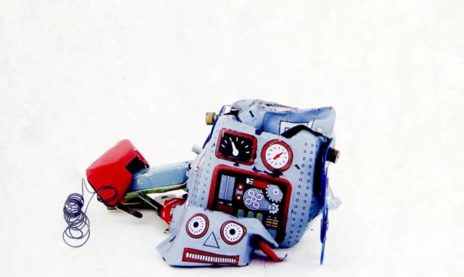 Broken toy robot on a white background, symbolising the risks of AI web design without a marketing agency or proper web development expertise.