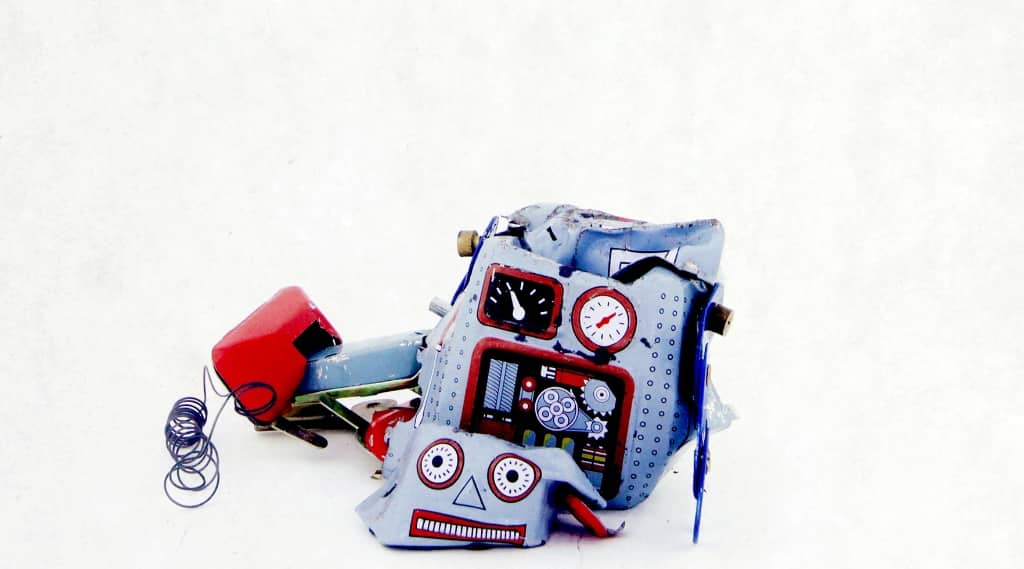 Broken toy robot on a white background, symbolising the risks of AI web design without a marketing agency or proper web development expertise.