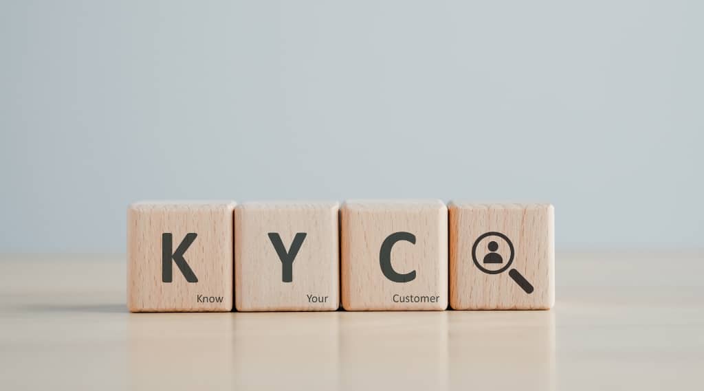 Wooden blocks spelling KYC for know your customer, linking tone of voice, pain points, writing blogs and website copy strategy.