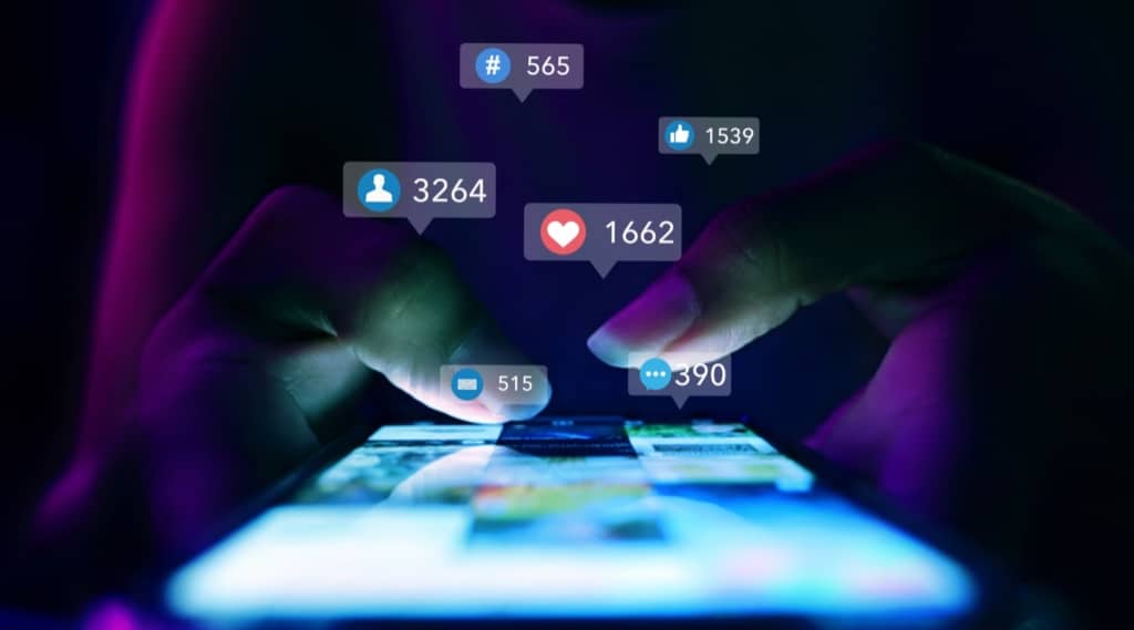 Close-up of hands on smartphone engaging with social ads and custom social media adverts.