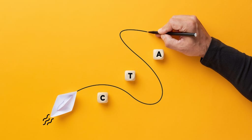 call to action mistakes, a hand drawing a winding line from a paper boat towards wooden blocks spelling CTA on a yellow background