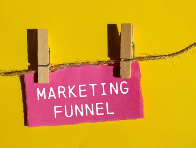 What is the marketing funnel: Marketing funnel sign clipped to a string against a yellow background, illustrating what a marketing funnel is and how it works.