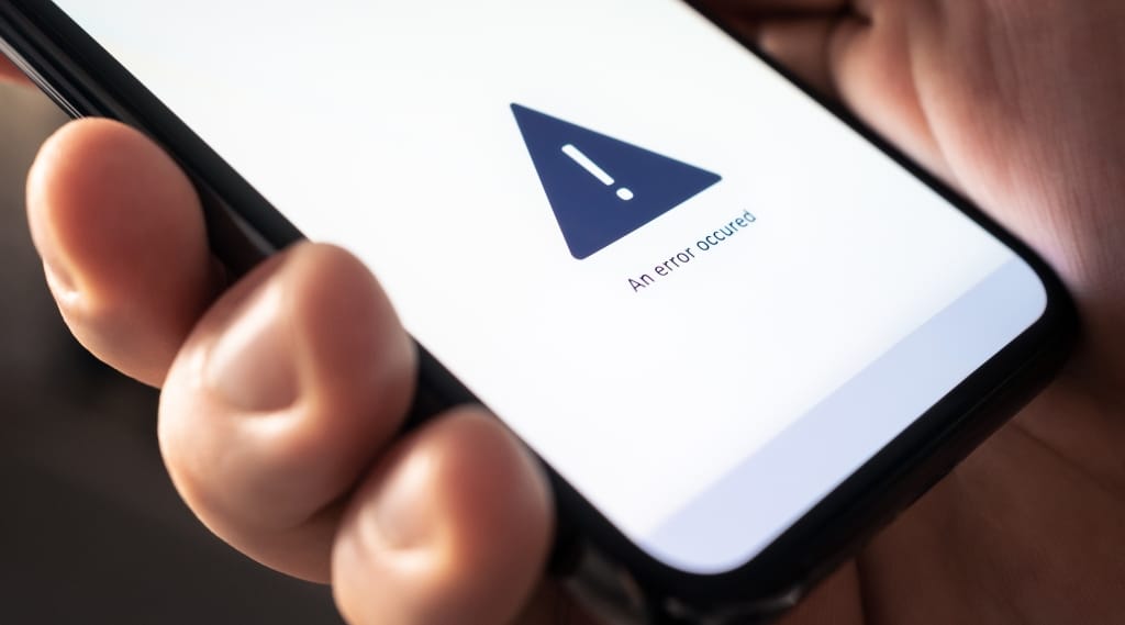 DIY Website Builder Problems, Close-up of a smartphone screen displaying an error message warning symbol, highlighting common DIY website builder problems.