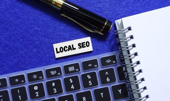 Keyboard and notebook with “Local SEO” label beside pen, representing local SEO strategies for improving search rankings.