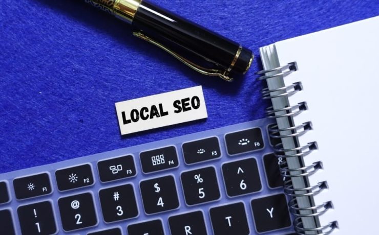 Keyboard and notebook with “Local SEO” label beside pen, representing local SEO strategies for improving search rankings.