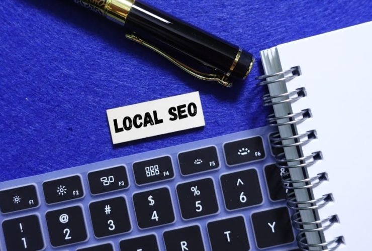 Keyboard and notebook with “Local SEO” label beside pen, representing local SEO strategies for improving search rankings.