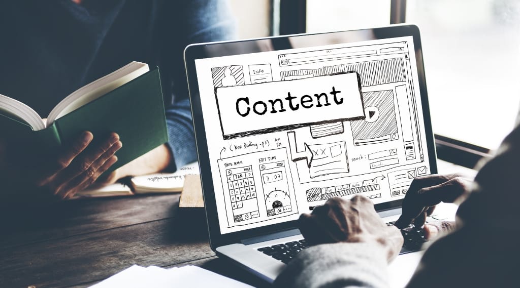 Person using laptop with website wireframe and content planning interface, representing web services in Portsmouth.