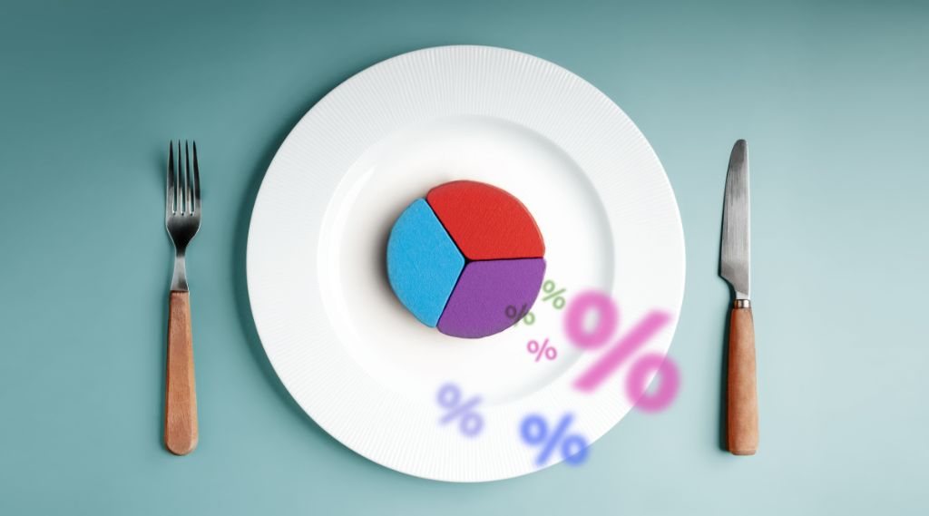 Where to invest marketing budget for small business: A white dinner plate between a fork and knife on a teal surface holds a small pie chart split into blue, red and purple segments, with colourful percentage symbols scattered around it.