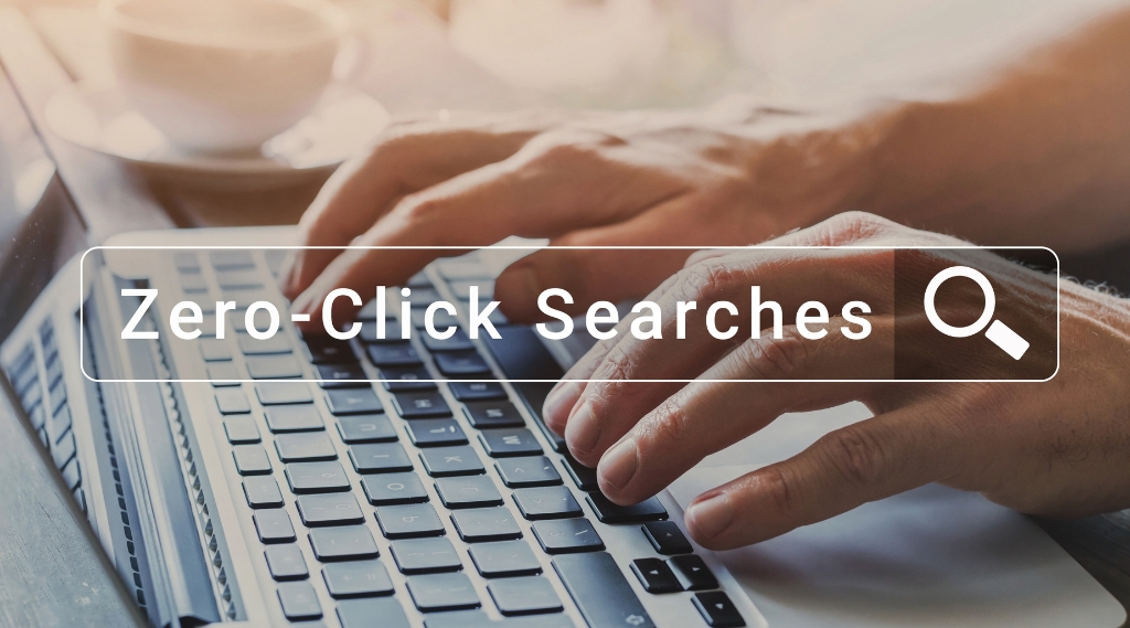 how do I know if ChatGPT is recommending my business: Hands typing on a laptop beneath a search bar overlay reading "Zero-Click Searches", illustrating how AI tools like ChatGPT answer questions and recommend businesses without users clicking through to a website.