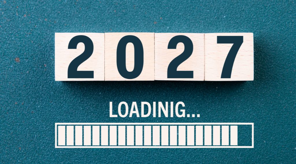 how much should I spend on marketing in 2027: Four wooden blocks spelling “2027” on a teal surface, above the word "Loading..." and a nearly full white loading bar.